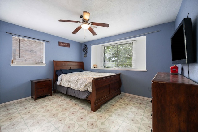 bedroom with ceiling fan and a textured ceiling