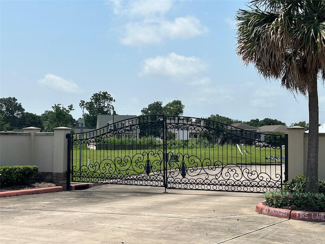 view of gate with a yard