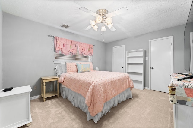 carpeted bedroom featuring a textured ceiling and ceiling fan