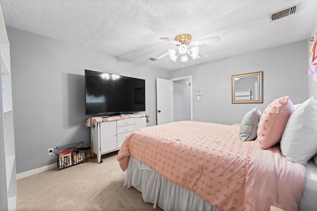 carpeted bedroom with ceiling fan and a textured ceiling