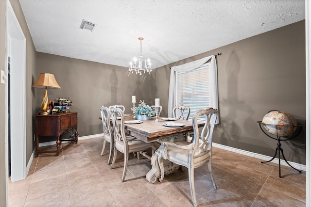 dining room featuring a notable chandelier and a textured ceiling