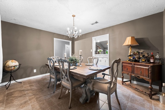 dining area featuring a textured ceiling and an inviting chandelier