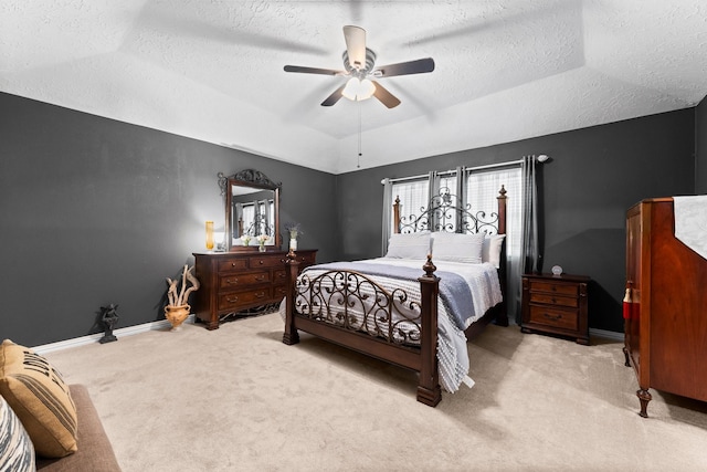 carpeted bedroom with a textured ceiling, vaulted ceiling, a raised ceiling, and ceiling fan