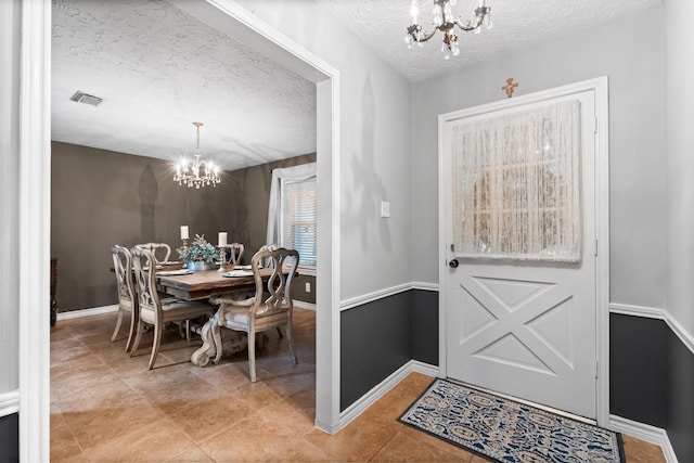 dining area featuring a notable chandelier and a textured ceiling