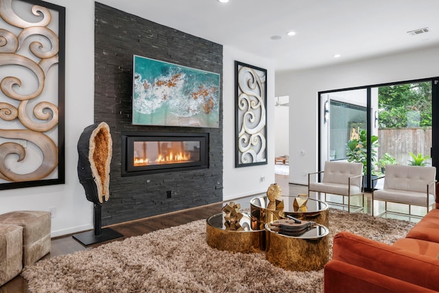 living room with wood-type flooring and a large fireplace