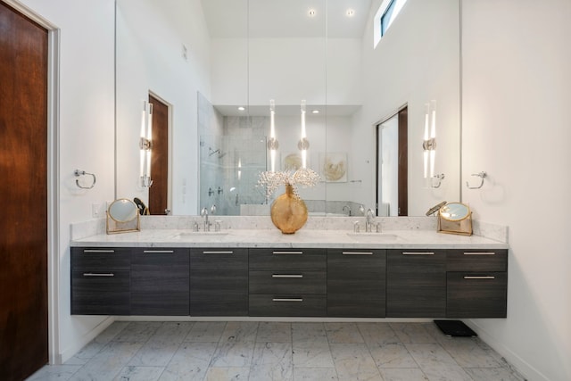 bathroom with walk in shower, vanity, and a high ceiling