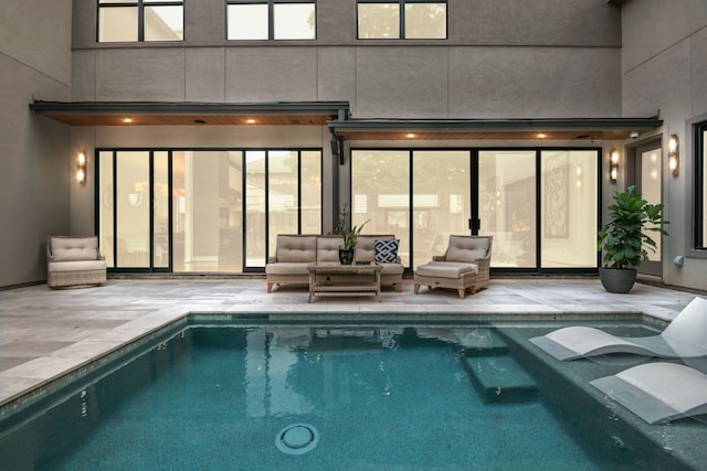 back of property featuring an indoor pool, an outdoor living space, and a patio