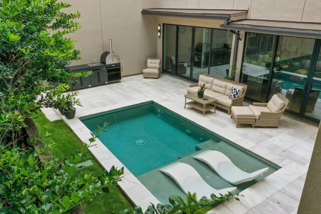 view of pool with an outdoor living space and a patio