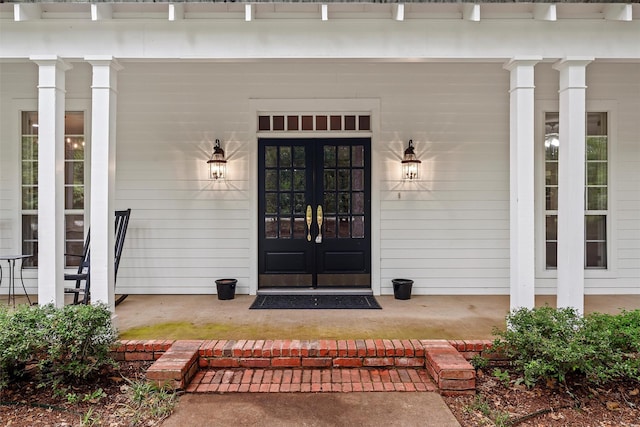 entrance to property with a porch and french doors