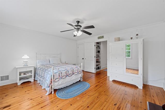 bedroom with light hardwood / wood-style floors, crown molding, and ceiling fan