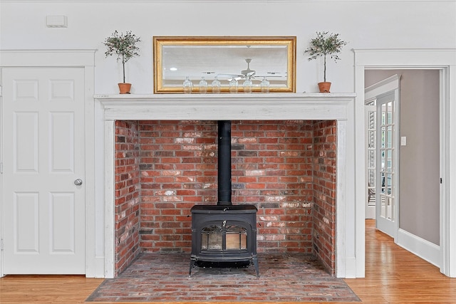 room details with a wood stove, baseboards, and wood finished floors