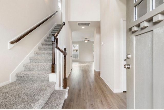 interior space featuring a high ceiling, ceiling fan, and light hardwood / wood-style flooring