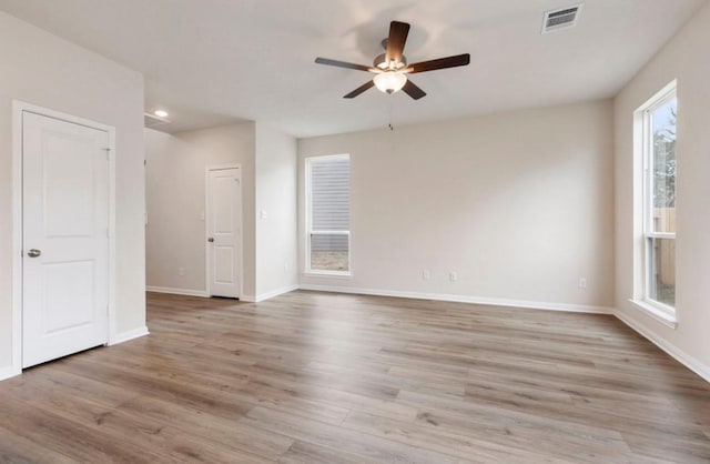 empty room with ceiling fan and light hardwood / wood-style floors