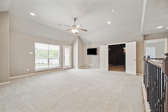 unfurnished living room with ceiling fan, lofted ceiling, and light carpet