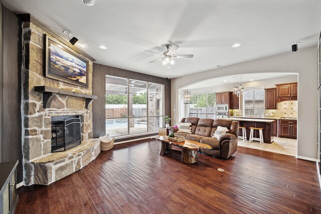 living room with a fireplace, ceiling fan with notable chandelier, and hardwood / wood-style flooring