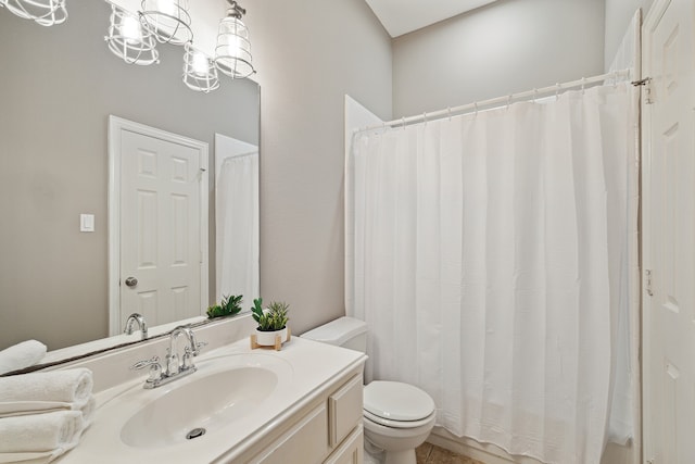 bathroom with vanity, toilet, and a notable chandelier