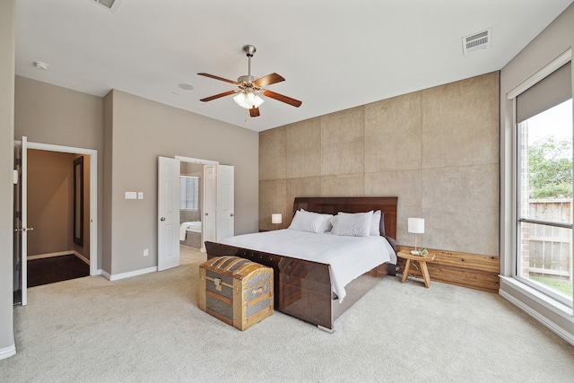 carpeted bedroom with ceiling fan and ensuite bathroom