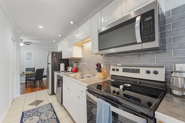 kitchen featuring light tile patterned flooring, sink, white cabinets, and stainless steel appliances