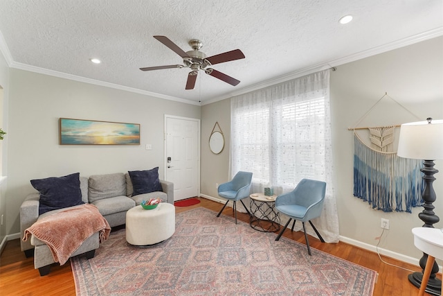 living room with crown molding, ceiling fan, a textured ceiling, and hardwood / wood-style flooring