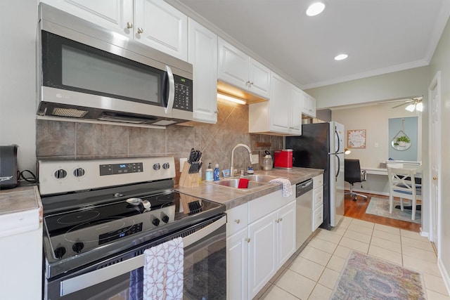 kitchen featuring crown molding, white cabinetry, sink, and appliances with stainless steel finishes