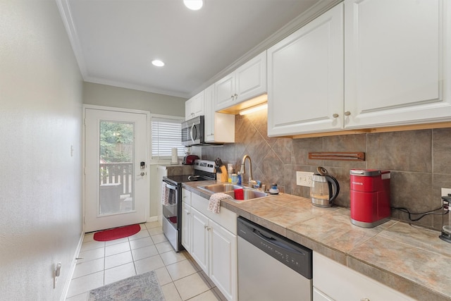 kitchen with tile countertops, sink, white cabinets, and stainless steel appliances