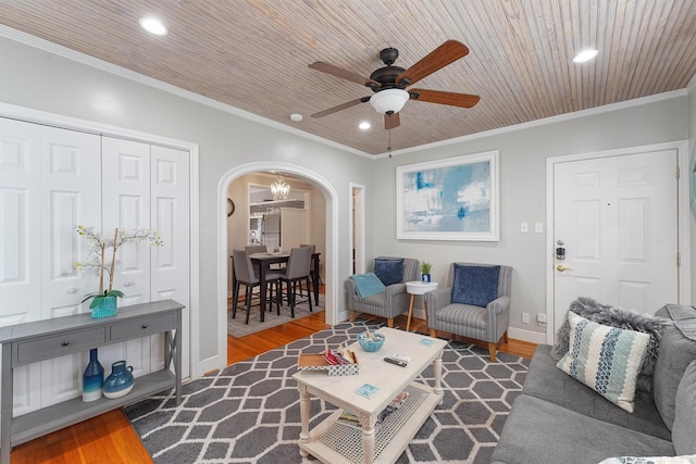 living room with wood-type flooring, ceiling fan, and crown molding