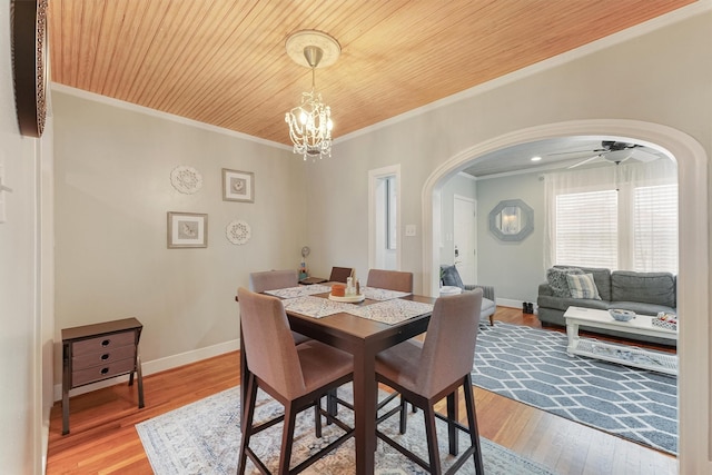 dining area with crown molding, light hardwood / wood-style flooring, wood ceiling, and ceiling fan with notable chandelier