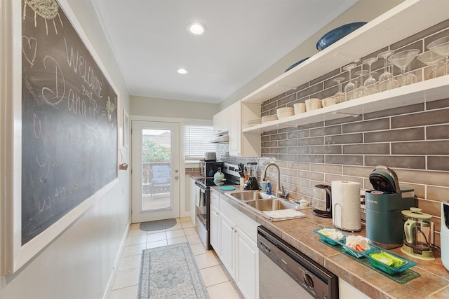 kitchen with tasteful backsplash, stainless steel appliances, sink, tile countertops, and white cabinetry