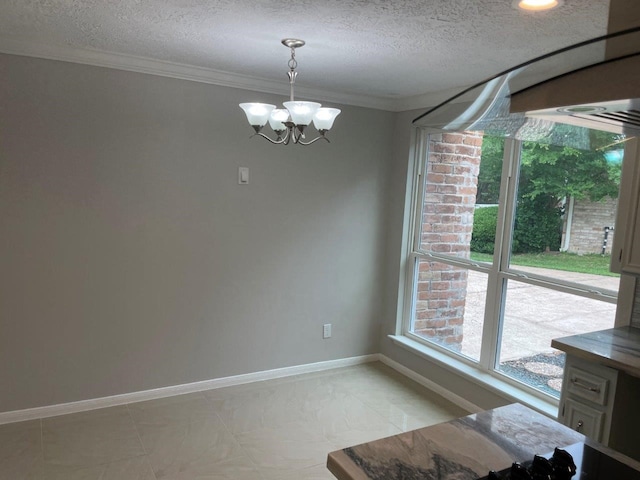 unfurnished dining area featuring ornamental molding, a textured ceiling, and an inviting chandelier