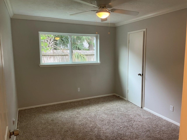 carpeted spare room featuring ceiling fan, a textured ceiling, and ornamental molding