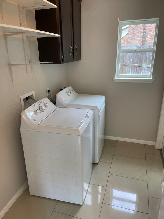 washroom featuring cabinets, light tile patterned floors, and separate washer and dryer