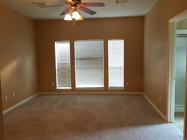 carpeted spare room featuring ceiling fan