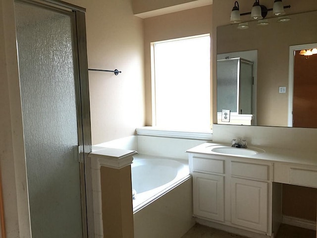 bathroom with vanity and shower with separate bathtub