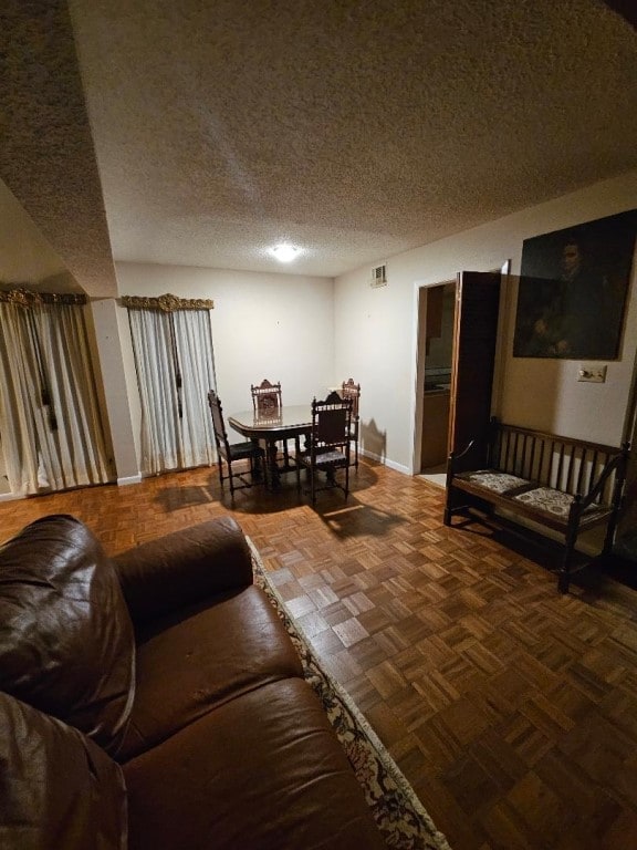 living room with dark parquet flooring and a textured ceiling