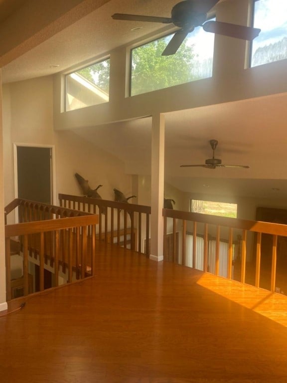 interior space featuring high vaulted ceiling, ceiling fan, plenty of natural light, and hardwood / wood-style flooring