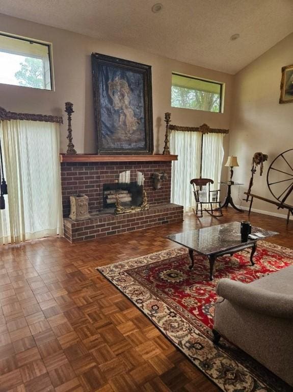 living room with baseboards, a textured ceiling, a brick fireplace, and high vaulted ceiling