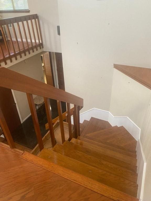 stairs with wood finished floors and baseboards