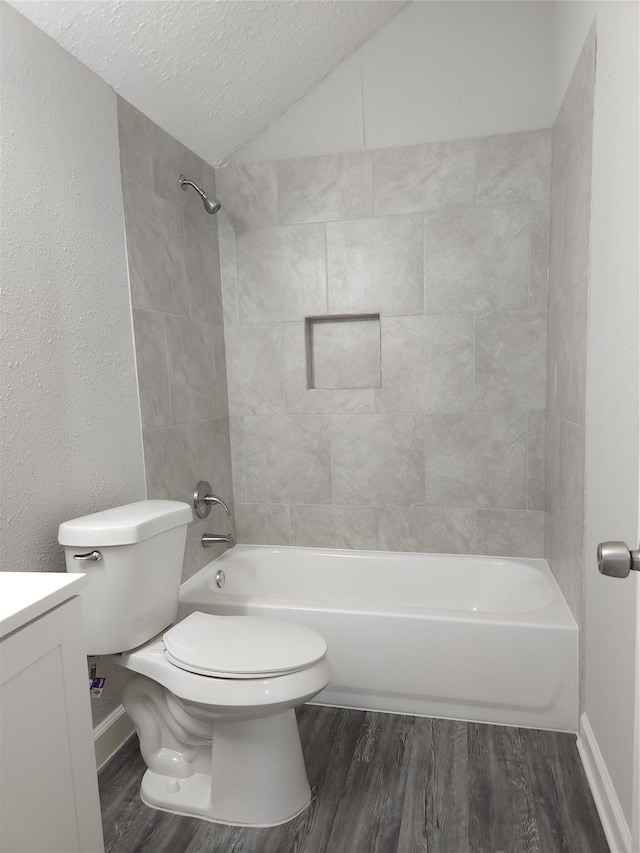 full bathroom featuring vanity, tiled shower / bath combo, toilet, a textured ceiling, and wood-type flooring