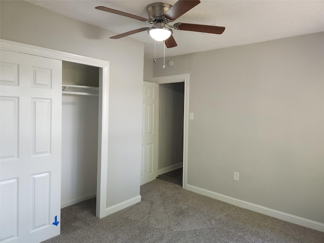 unfurnished bedroom featuring ceiling fan, a closet, light colored carpet, and a textured ceiling