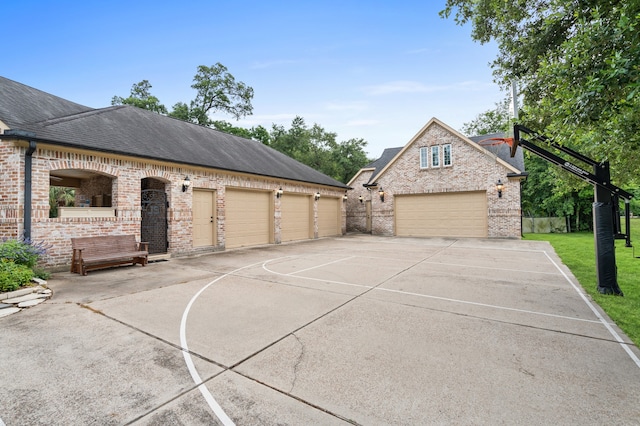 exterior space featuring a garage and basketball hoop