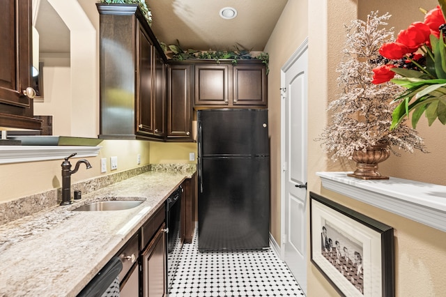 kitchen with black appliances, dark brown cabinets, light stone counters, and sink