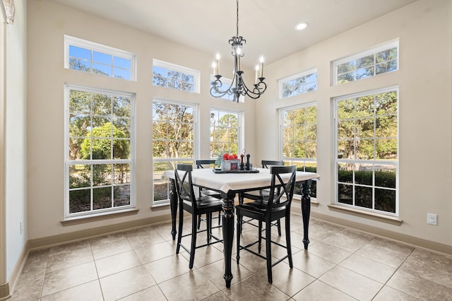 dining room with a towering ceiling, a notable chandelier, and light tile patterned flooring