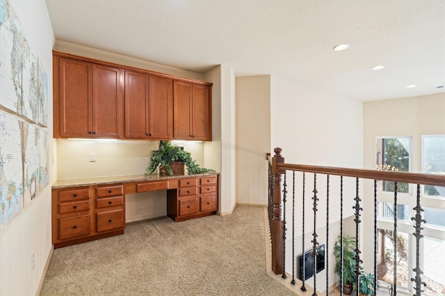 carpeted home office with built in desk