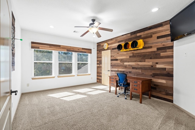 unfurnished office with carpet, ceiling fan, and wooden walls