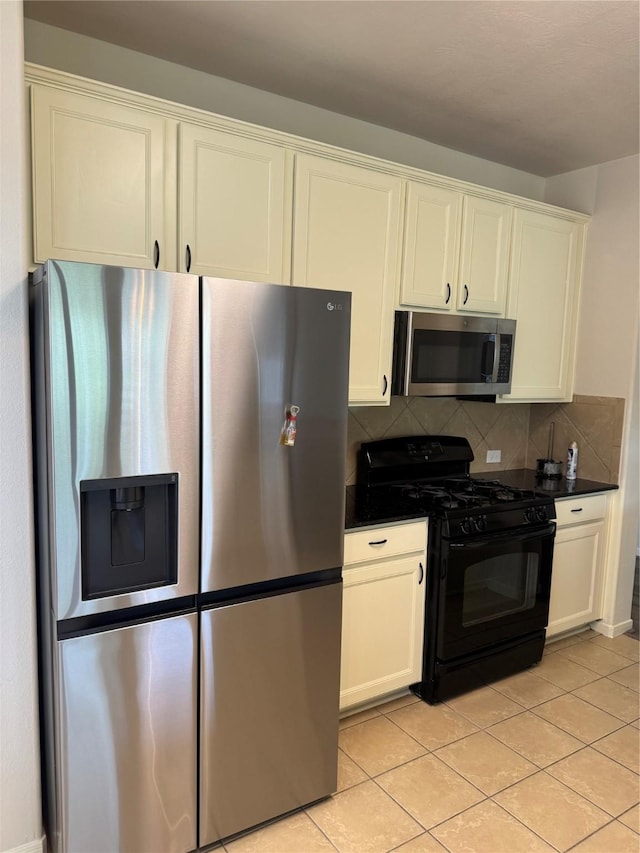 kitchen with light tile patterned floors, white cabinets, stainless steel appliances, and tasteful backsplash