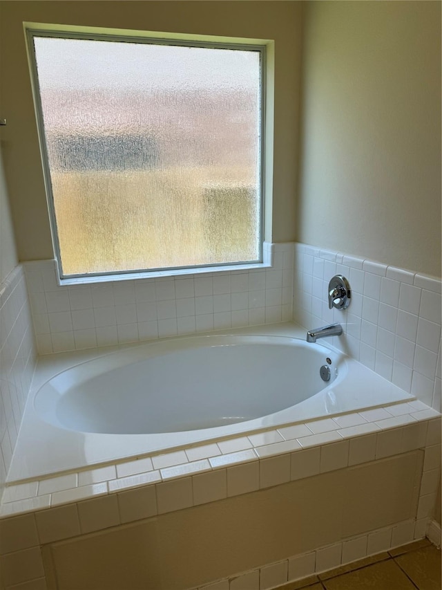 bathroom with tile patterned floors and a relaxing tiled tub