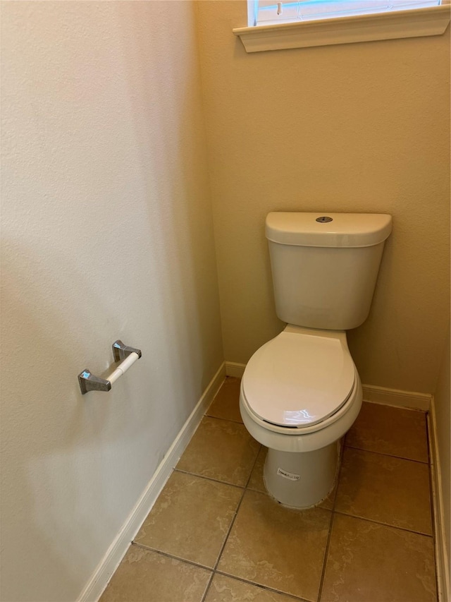 bathroom with toilet and tile patterned flooring