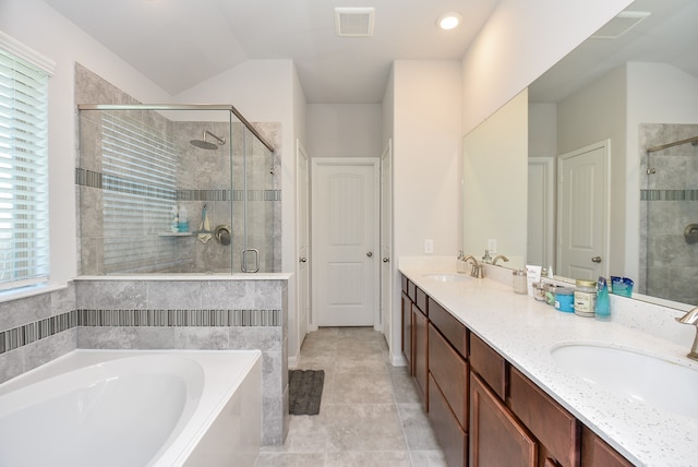 bathroom featuring dual sinks, tile flooring, vanity with extensive cabinet space, and separate shower and tub