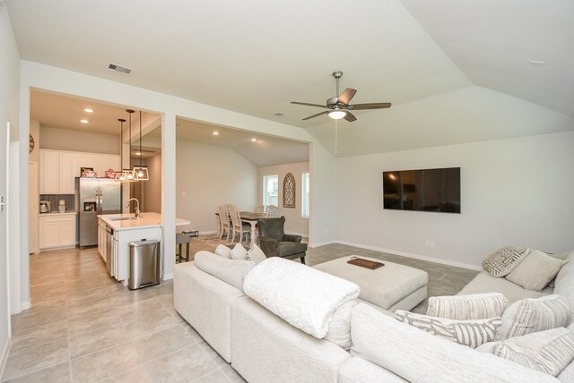 tiled living room featuring sink, lofted ceiling, and ceiling fan