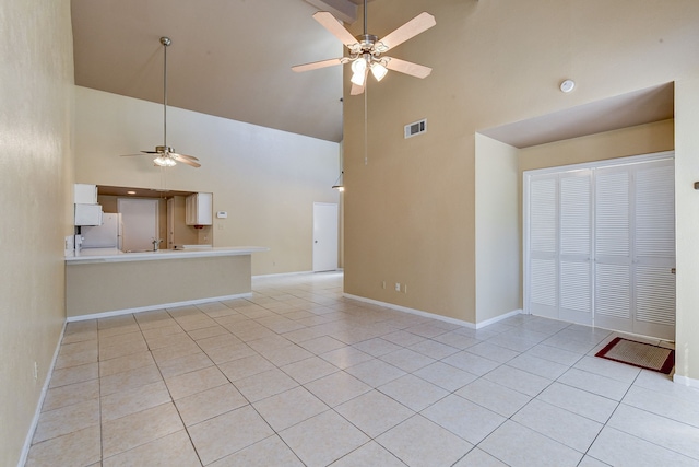 unfurnished living room featuring ceiling fan, light tile patterned floors, and high vaulted ceiling